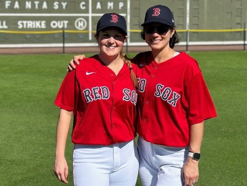 Natalie and Kaitlyn on a baseball field wearing Red Sox jerseys