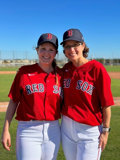 Natalie and Kaitlyn on a baseball field wearing Red Sox jerseys