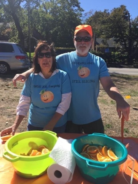 The Orange Guy and his wife passing out oranges