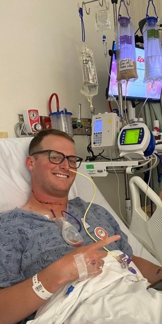 Sam lies in a hospital bed attached to IVs