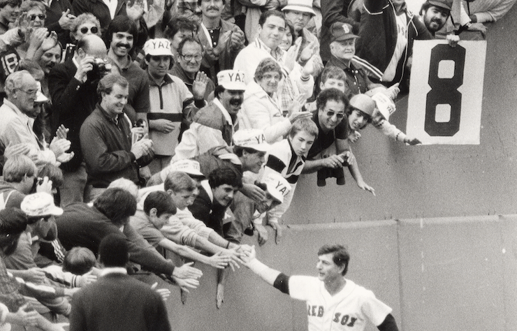 Black and white photo of Carl Yastrzemski entering the field at Fenway Park, high-fiving fans