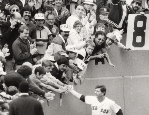 Black and white photo of Carl Yastrzemski entering the field at Fenway Park, high-fiving fans